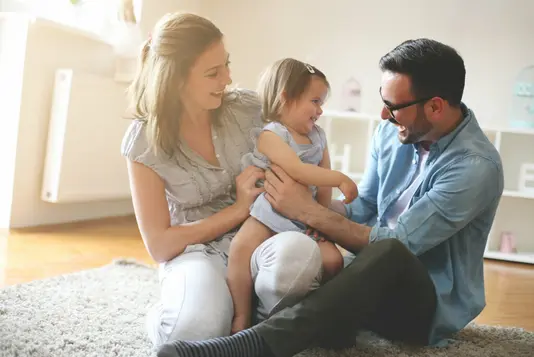 Haus-Familie-Wohnen-Serie-23-11 Glückliche Familie sitzt auf dem Fussboden mit ihrer Tochter.