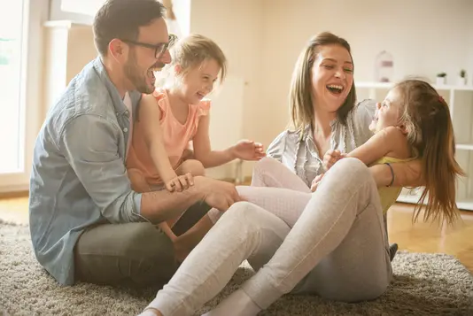 Baufinanzierung-Eigenleistung-Finanzierungsservice Glückliche Familie im Wohnzimmer